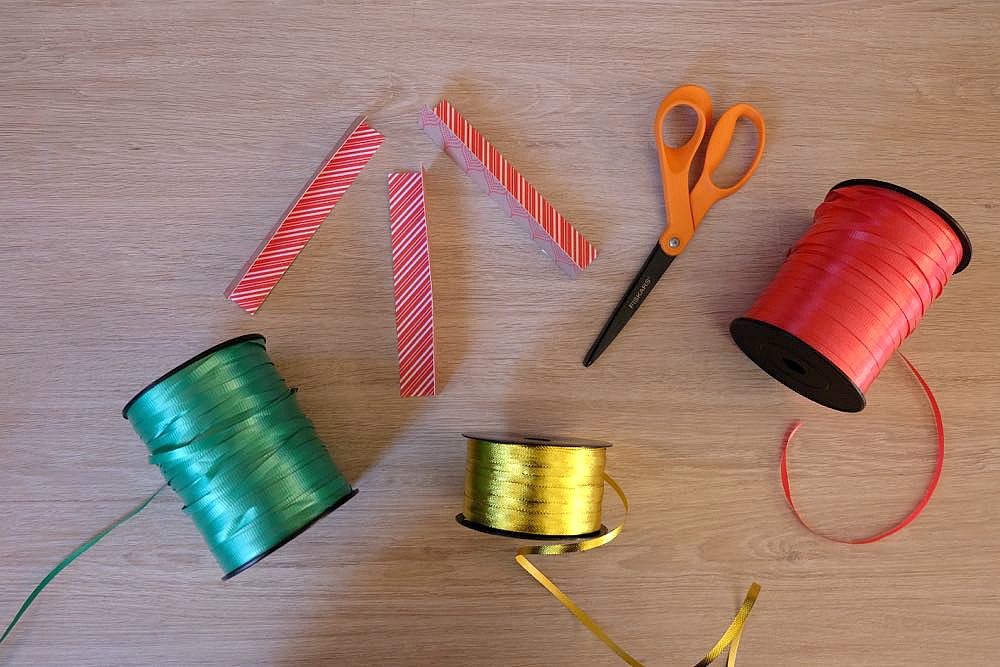 Skip the store bought bows and DIY them instead! Learn How To Make Super Simple DIY Poinsettia Bows For Gift Wrapping. They are so easy and perfect for wrapping Christmas gifts!