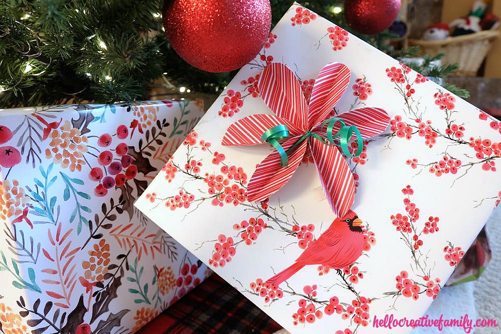 Skip the store bought bows and DIY them instead! Learn How To Make Super Simple DIY Poinsettia Bows For Gift Wrapping. They are so easy and perfect for wrapping Christmas gifts!