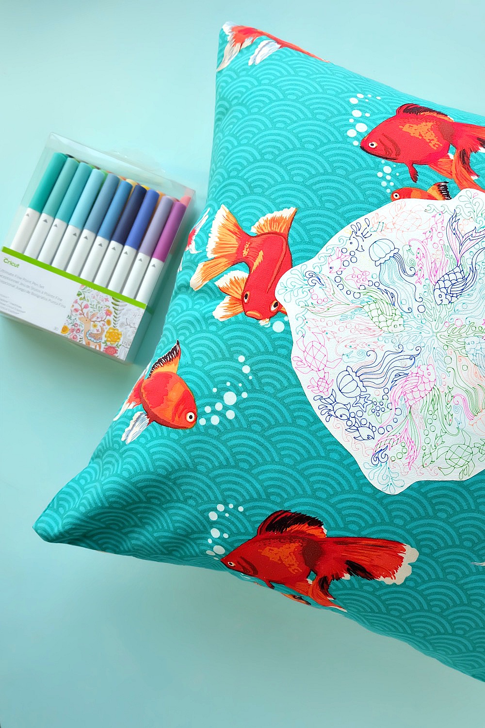 Create a gorgeous DIY Rainbow Under the Sea Pillow using your Cricut Explore to draw a coloring page design on printable heat transfer vinyl! This is an easy project that makes bright and colorful handmade gift idea. Includes instructions on how to sew an envelope style throw pillow cover. #CricutMade