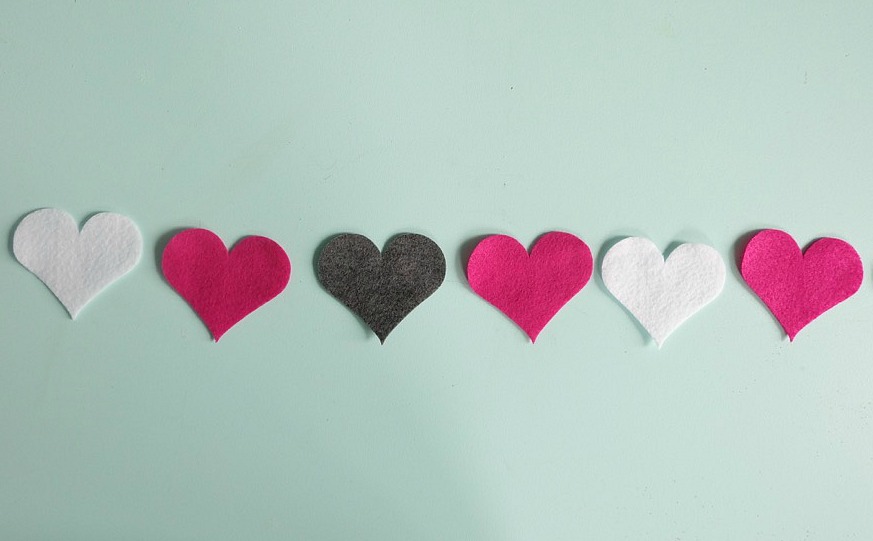 Decorate for Valentine's Day with this easy 5 minute Felt DIY Heart Garland! Customize this project with different colors of felt. So cute not only for decorating the home but also to decorate a classroom or to use as a photo prop! Cut your hearts by hand or with a Cricut Maker. A great first sewing project for kids! #Cricut #craft #ValentinesDay