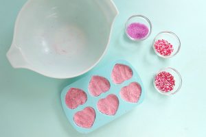 Divide your bath bomb mixture between the cavities of your silicone mold. Press the mixture firmly into the mold. Your bath bomb mixture should be packed down firmly.