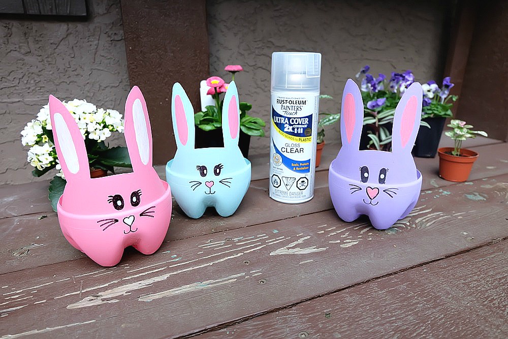 These DIY Easter Bunny Planters are made using recycled pop bottles! Bright and colorful they are a fun craft for a table centerpiece, front porch or handmade Easter gift idea! An easy upcycled kids Easter Craft to keep little ones occupied during spring break and to teach gardening skills. #Easter #Crafts #Upcycled HandmadeGift #Gardening