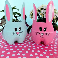 These DIY Easter Bunny Planters are made using recycled pop bottles! Bright and colorful they are a fun craft for a table centerpiece, front porch or handmade Easter gift idea! An easy upcycled kids Easter Craft to keep little ones occupied during spring break and to teach gardening skills. #Easter #Crafts #Upcycled HandmadeGift #Gardening