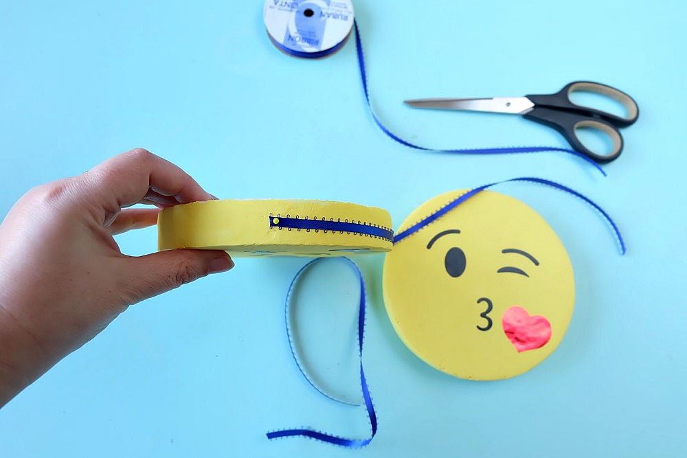 The perfect DIY project to complete an emoji themed kids room or an emoji birthday party! These DIY Emoji Door Hangers are easy to make and a fun kids craft. Use your Cricut to cut the his and her kissy face emoji faces and apply them to painted styrofoam disks. #CricutMade #Emoji #DIY #KidsCrafts