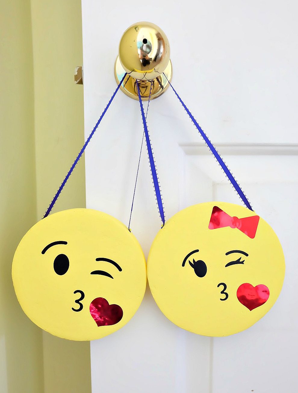 The perfect DIY project to complete an emoji themed kids room or an emoji birthday party! These DIY Emoji Door Hangers are easy to make and a fun kids craft. Use your Cricut to cut the his and her kissy face emoji faces and apply them to painted styrofoam disks. #CricutMade #Emoji #DIY #KidsCrafts