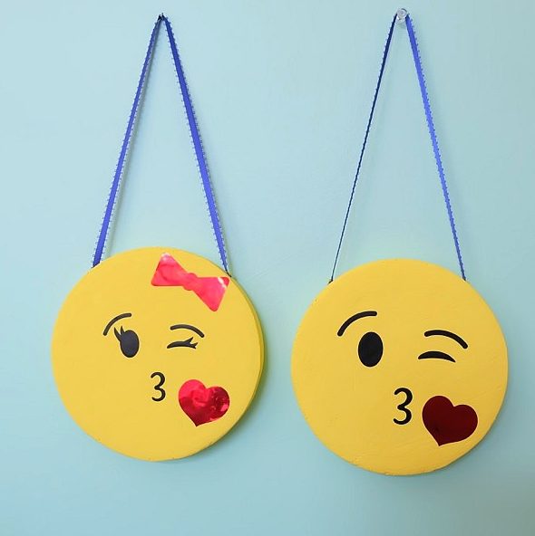 The perfect DIY project to complete an emoji themed kids room or an emoji birthday party! These DIY Emoji Door Hangers are easy to make and a fun kids craft. Use your Cricut to cut the his and her kissy face emoji faces and apply them to painted styrofoam disks. #CricutMade #Emoji #DIY #KidsCrafts