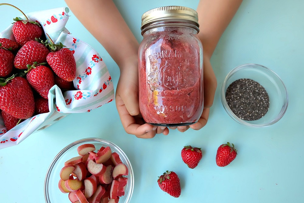 This quick and easy strawberry rhubarb chia jam takes two of my favorite flavors of summer and turns it into one healthy recipe! If you have never made jam before this is the recipe to start with. It uses chia seeds to thicken the jam and takes only 15 minutes start to finish to make! Family friendly, get the kids involved in the kitchen helping to make this delicious treat. Perfect for on bread, mixed with greek yogurt or as an ice cream topper! #Jam #chia #strawberry #rhubarb #recipe