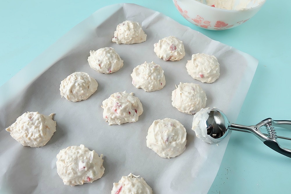 Strawberries, rhubarb, coconut and frothy egg whites come together in one delicious dessert in this Strawberry Rhubarb Coconut Meringue Cookie Recipe. These pretty cookies are perfect for a summer tea party and are simple to make. Sure to become a family favorite! #cookies #recipe #strawberry #rhubarb #strawberryrhubarb