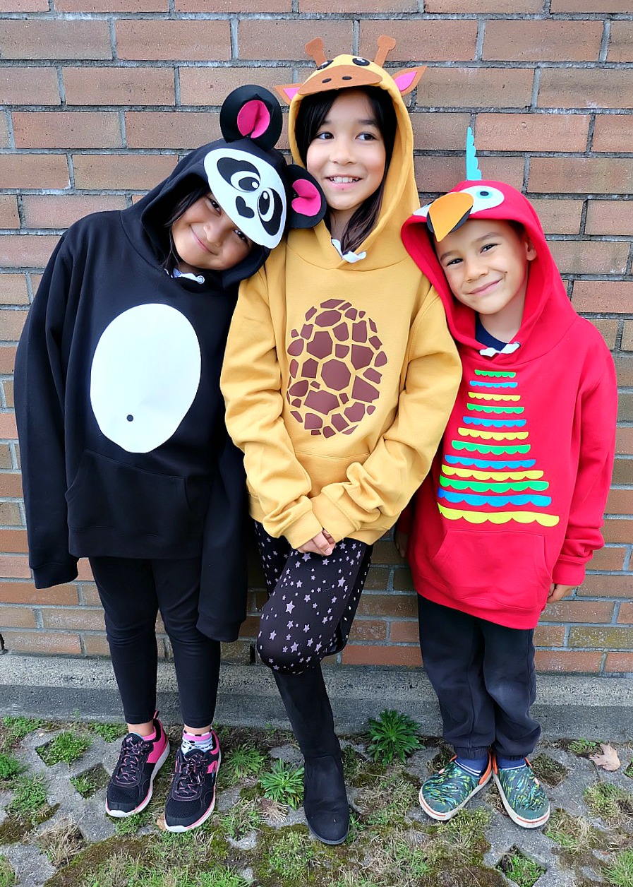 Looking for a fun idea for DIY No Sew Group Halloween Costumes? Look no further! We used HTV, felt a glue gun and our Cricut Maker to create these adorable zoo animal hoodies. We've got free cut files for a giraffe, parrot and panda! Make all three for a fun group halloween costume for kids or adults! #Halloween #DIY #GroupCostume #CricutMaker #Cricut #CricutMade #Sponsored