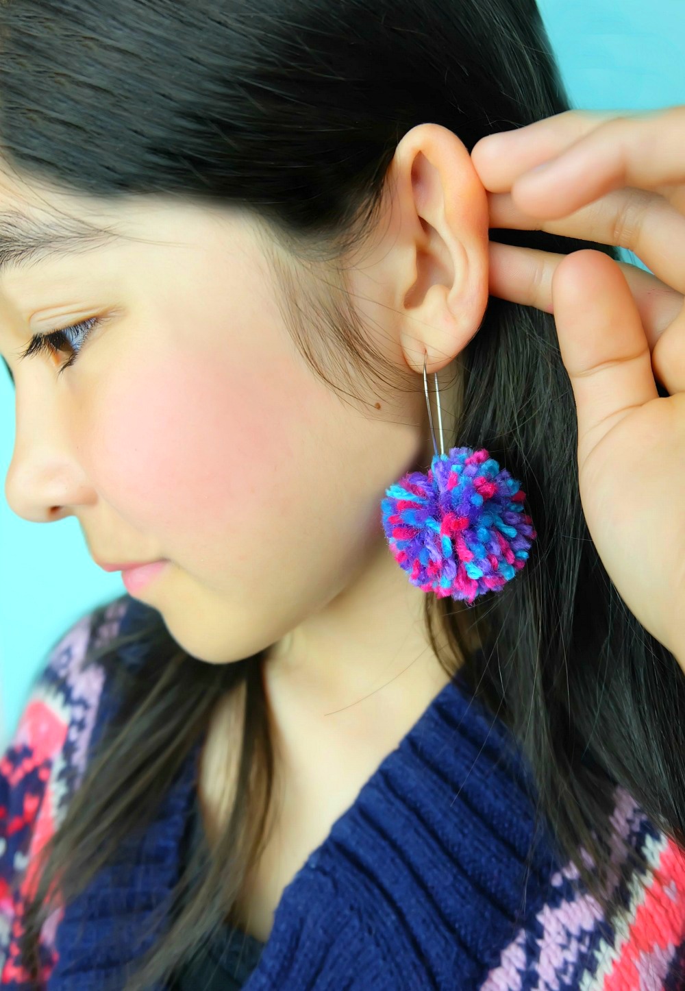 Learn how to make DIY Pom Pom Earrings in minutes with this quick and easy tutorial! Make an adorable pair of earrings to match any outfit! Also learn how to make a DIY pom pom maker in any size using a piece of cardboard! This would make an adorable handmade gift for teens or tweens! #DIY #Craft #pompoms #Earrings