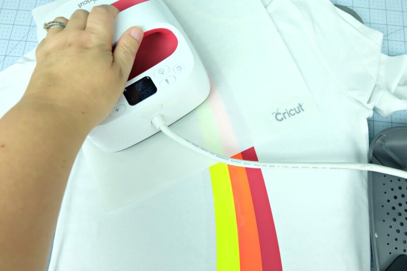 Ue your Cricut EasyPress to apply heat transfer vinyl to create a rainbow shirt. 