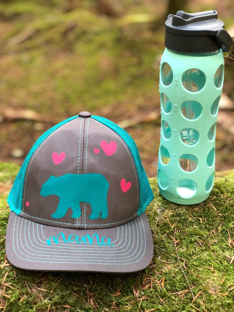 Make a DIY Mama Bear Trucker Hat using your Cricut with our easy step by step instructions! The perfect handmade gift for moms, new mamas and mommies to be! So fun to wear camping and in the great outdoors! An easy project for the Cricut Maker or Cricut Explore! #CricutCreated #CricutMade #DIYCamping #MomGift #Sponsored 