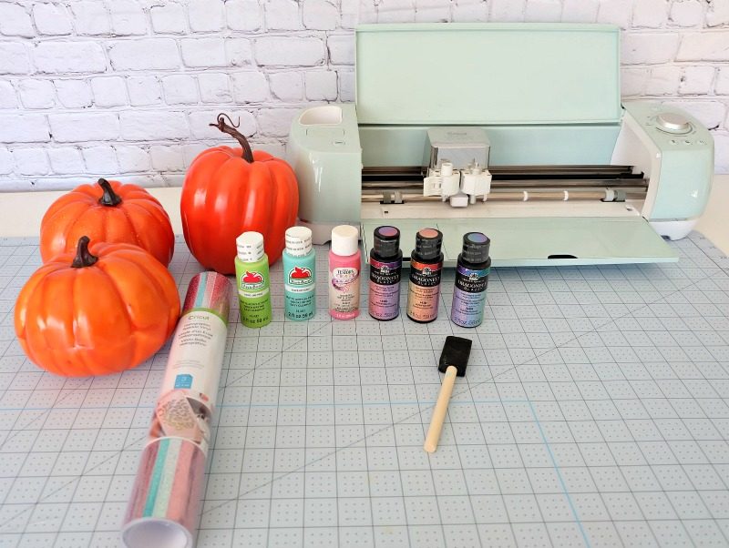 Add some flare to dollar store craft pumpkins with our easy painted pumpkins tutorial! With a bit of paint and some vinyl decals you cut with your Cricut this project makes a fun family friendly Halloween craft! #DIYHalloween #CricutCreated #Cricut #CraftPumpkins