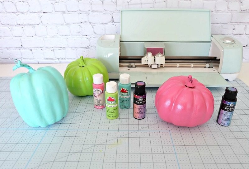 Add some flare to dollar store craft pumpkins with our easy painted pumpkins tutorial! With a bit of paint and some vinyl decals you cut with your Cricut this project makes a fun family friendly Halloween craft! #DIYHalloween #CricutCreated #Cricut #CraftPumpkins