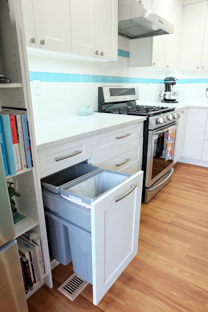 Finding the perfect garbage and recycling center for your family's needs is such an important consideration to make when doing a kitchen remodel. This DIY teal kitchen remodel includes a colorful aqua island and other smart features. Also check out her 20 Tips for a Smooth Kitchen Renovation! #Sponsored #Turquoise #Kitchen #Aqua #KitchenRemodel #kitchenrenovation