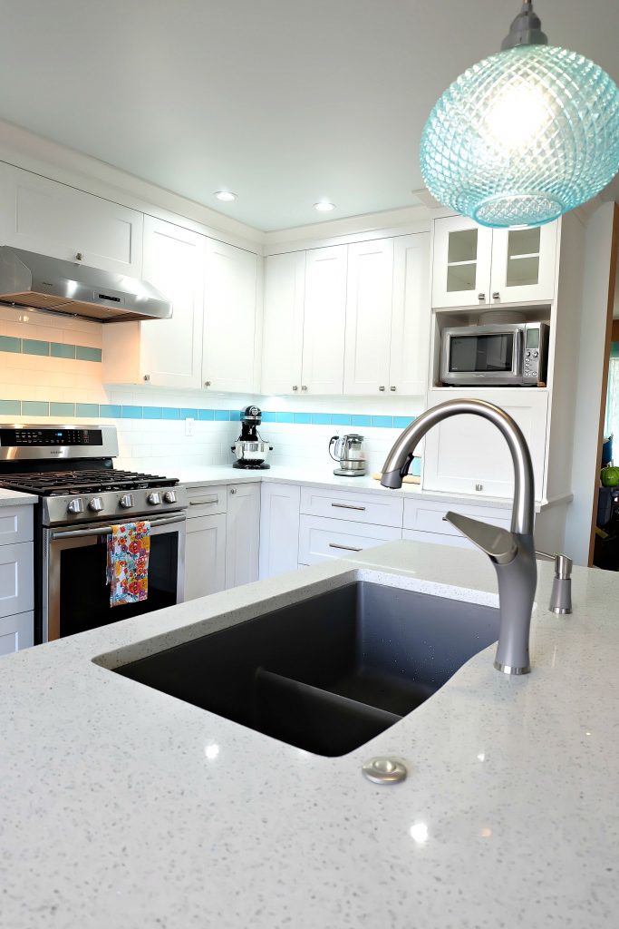Blanco's Silgranit Diamond U 2 Low Divide Sink and Artona Kitchen Faucet are a great way to add a pop of neutral grey to a bright aqua kitchen space! This DIY turquoise kitchen remodel includes a colorful island and other smart features.  #Sponsored #Turquoise #Kitchen #Aqua #KitchenRemodel #kitchenrenovation