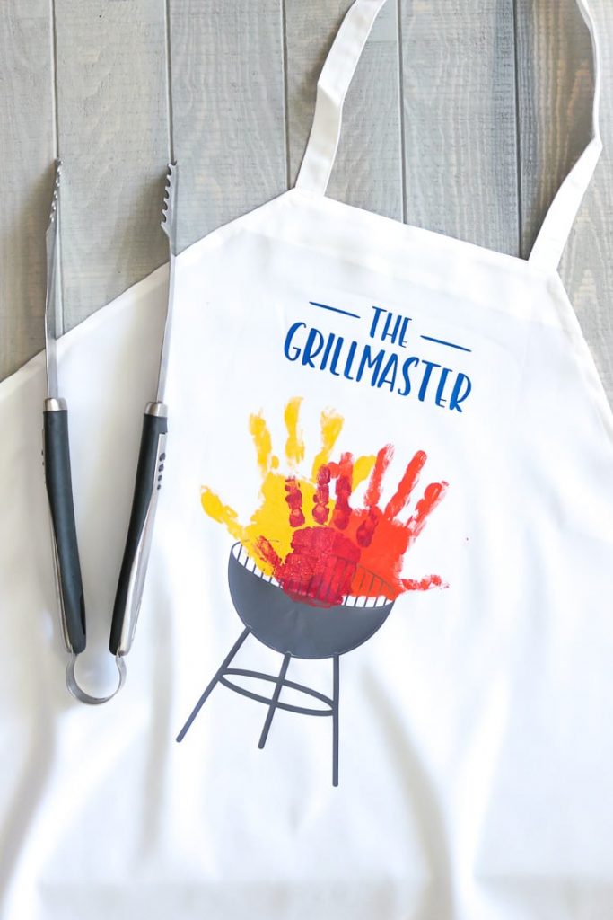 27 Cricut Gift Ideas That Take 1 Hour Or Less To Make: Handprint Grill Master Father's Day Apron from That's What Che Said
