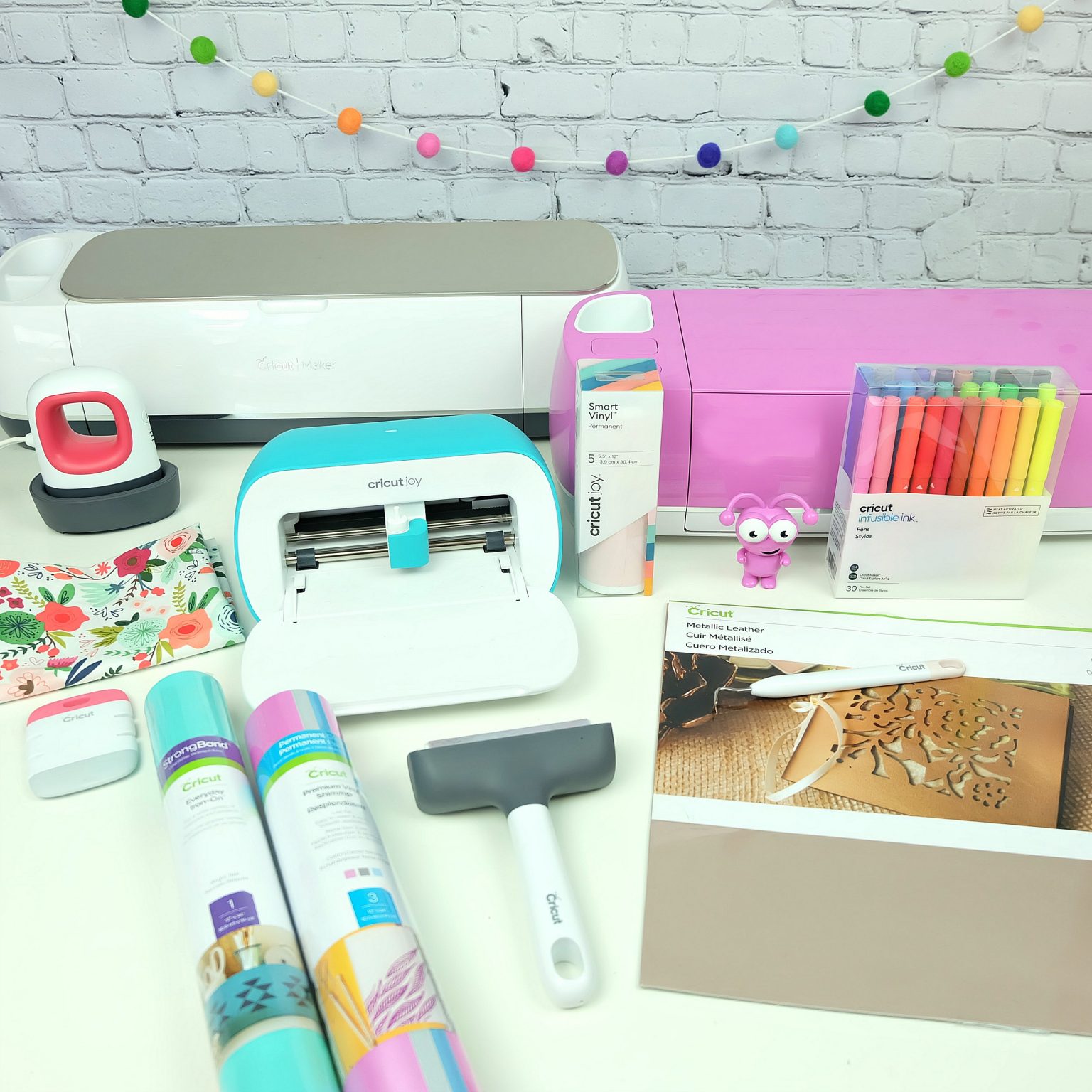 Craft table set up with Cricut Maker, Cricut Explore Air 2 Cricut Joy and Cricut craft supplies. 