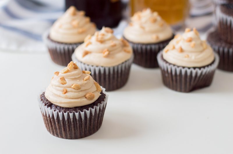 The perfect dessert to steal a man's heart-- our Chocolate Beer Cupcakes Recipe! With chocolate and beer in the batter, a peanut butter buttercream frosting and salty peanuts sprinkled on top, this recipe is the ultimate dad dessert! Perfect for Father's Day, birthdays and just because! #Cupcakes #Beer #Recipe #BeerRecipe #ChocolateCupcakes #FathersDay #Dessert #FathersDayCupcakes #FathersDayDessert #BeerRecipes
