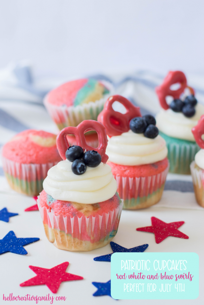 Celebrate the Fourth of July with this Patriotic Cupcakes Recipe! With red, white and blue swirls, buttercream frosting, hand dipped candy coated pretzels and blueberries, this is a fun Fourth of July Cupcake decorating idea! Great for other patriotic holidays too! Who doesn't love red, white and blue food ideas! #Cupcakes #FourthOfJuly #Patriotic #Baking #CupcakeDecorating #Recipe #CupcakeRecipe #RedWhiteAndBlue #PatrioticFood