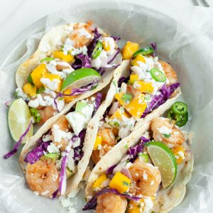 What's for dinner? This homemade shrimp tacos recipe with mango salsa is fresh, healthy and delicious! This easy 30 minute dinner meal idea is made with whole foods and delicious flavors that the entire family will love! #Tacos #Shrimp #mango #recipe #summer #cilantro #30minutemeal #homemade #Easy #mealplanning