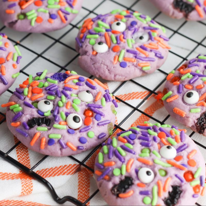 They're creepy and they're kookie, they're all together spooky! Grab this easy Monster Mash Halloween Sugar Cookie Recipe for baking with kids! Perfect for family Halloween fun and classroom Halloween party snack ideas! #Recipe #cookies #Halloween #Monster #PurpleFood #FamilyFriendly #CookingWithKids #Homemade
