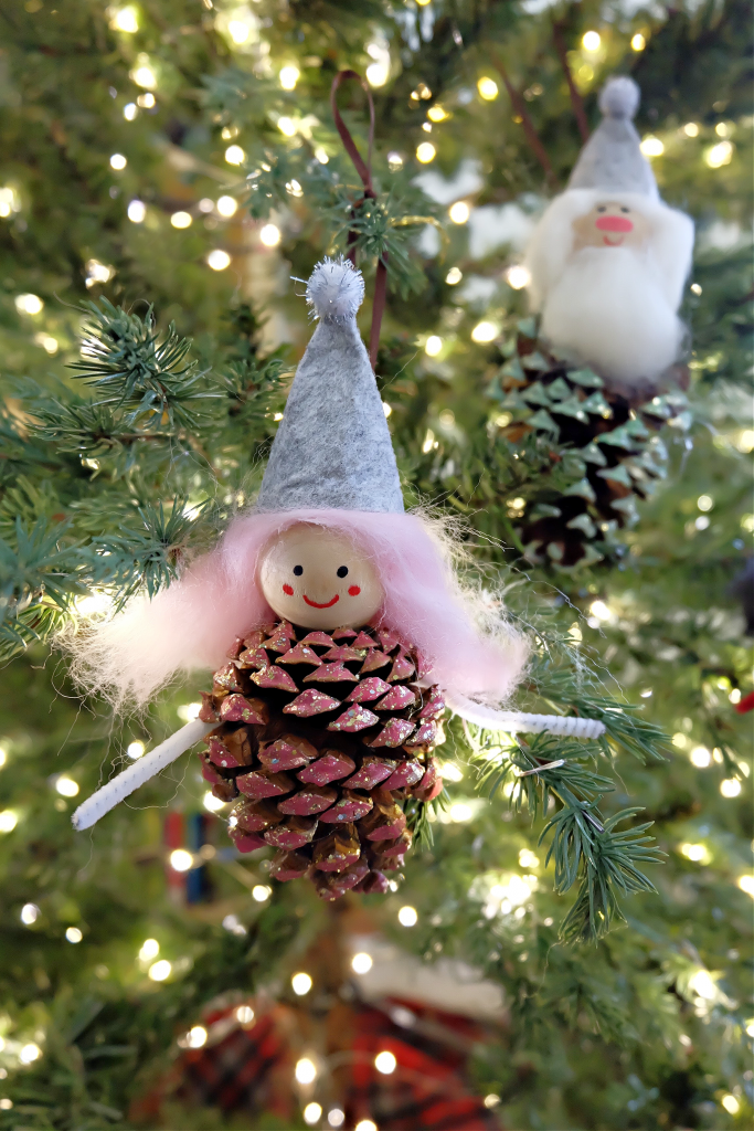 These sweet little DIY Forest Gnome Pinecone Christmas Ornaments are so FUN and look super cute hanging from the tree! A fun family Christmas craft project using pinecones you can find on a nature walk! Pinecone crafts  are festive for both fall and Christmas! #ChristmasCrafts #PineconeCrafts #DIY #Crafts #FamilyCrafts #KidsCrafts #Pinecones #Christmas #Gnomes #ChristmasGnomes #ChristmasElves #FeltCrafts #kidscrafts