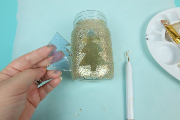 Removing the stencil from the glitter mason jar.