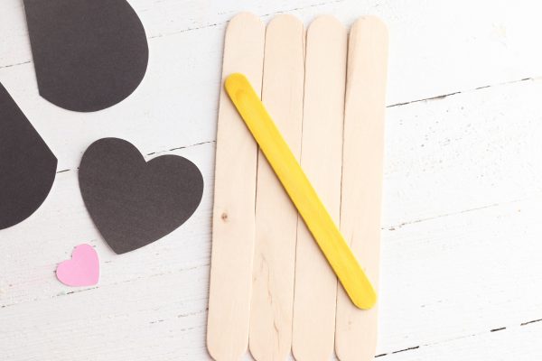 Lay the large popsicle sticks on a flat surface and glue the small stick to the back to hold them in place.