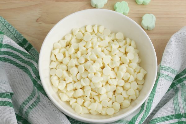 Place the white chocolate chips in a microwave safe bowl and microwave in 30 second intervals, stirring between each interval, until the chocolate chips are fully melted.