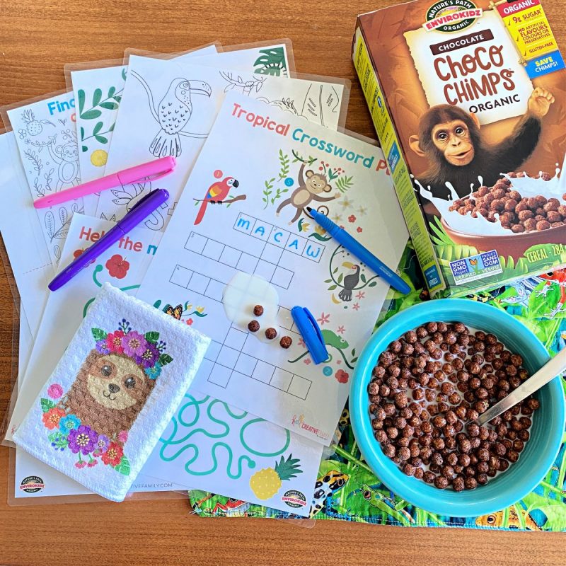 Laminated Rainforest Activity Sheet Printable Bundle with a bowl of ChocoChimps EnviroKidz Cereal! Milk and cereal is spilled on the laminated pages.