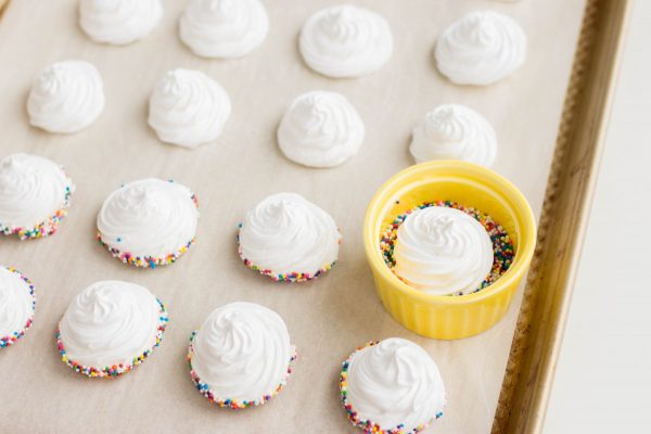 Dip the bottom of each meringue cookie into the melted chocolate, then dip into the sprinkles.