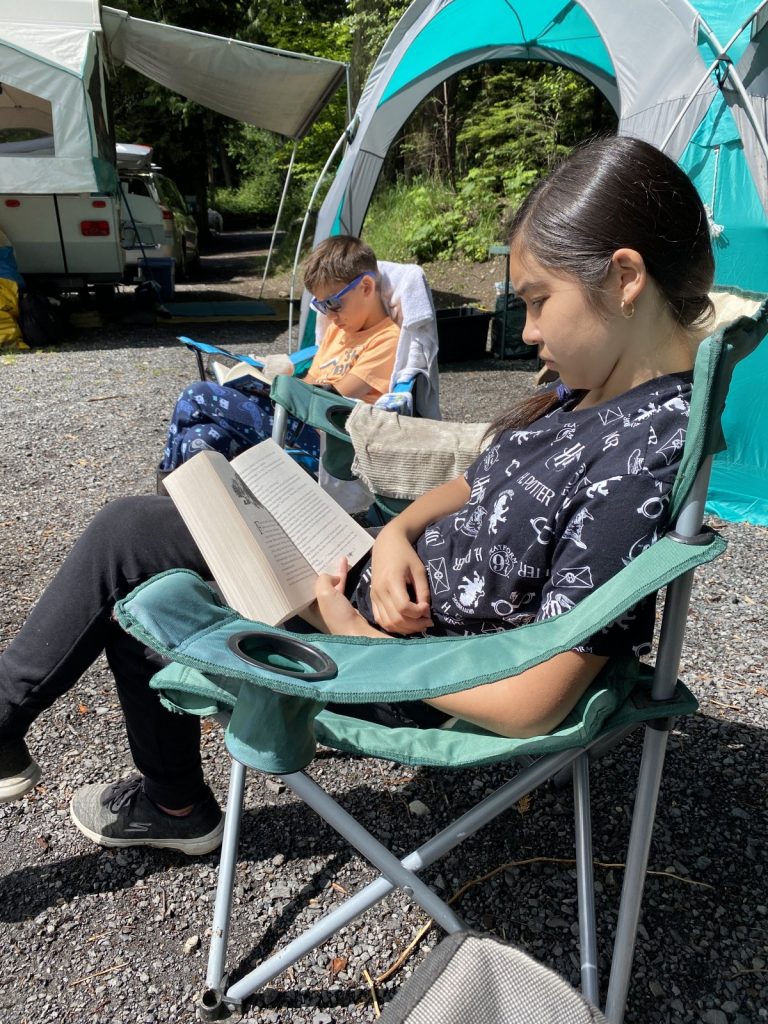 Hello Creative Family kids reading books while camping.