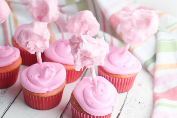Form a ball with a small amount of cotton candy and place the ball on top of a paper straw. Place the straw in the cupcake. Continue this process until all the cupcakes are decorated.