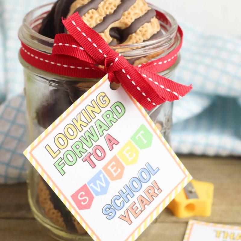 Sweet handmade teacher gift. Mason jar with cookies with an pretty colorful gift tag that says Looking Forward To A Sweet School Year. 