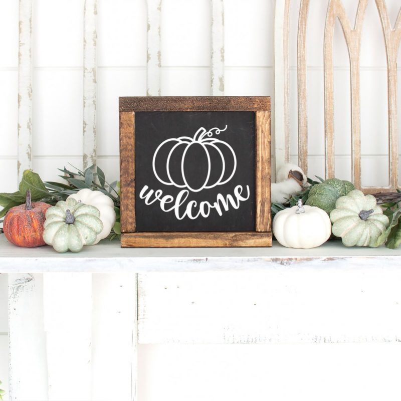 DIY Wood sign on a mantle with the word welcome and a hand drawn pumpkin. 