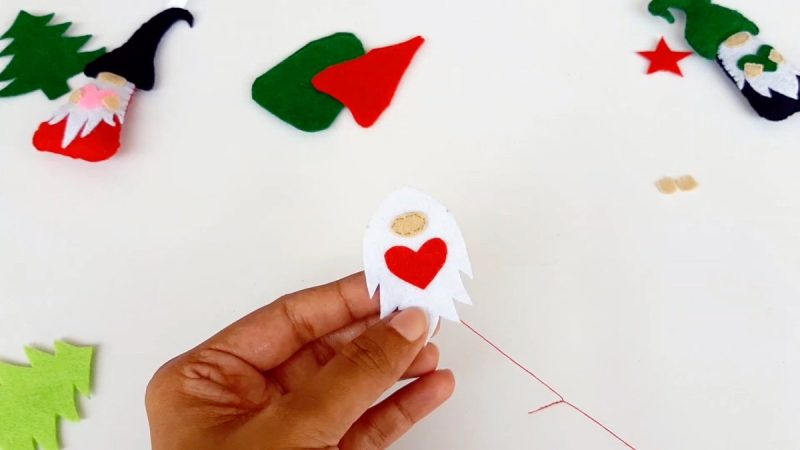 Sew the nose, heart and hands onto the beard using embroidery floss and a running stitch.