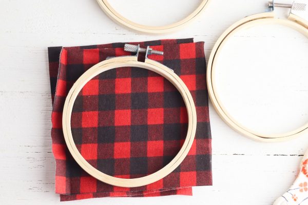 Cut a piece of flannel fabric to fit inside the embroidery hoop.