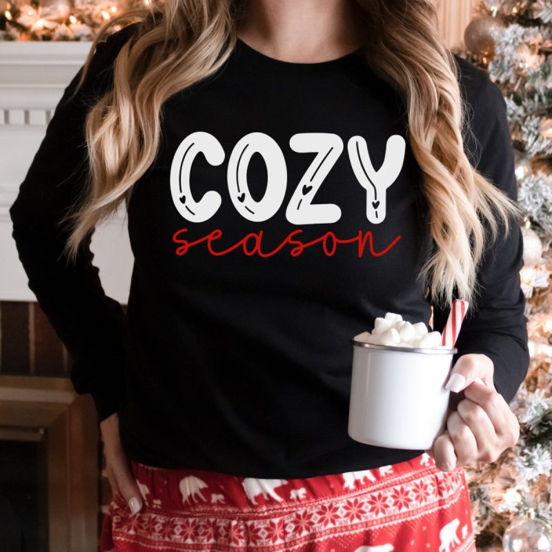 Woman with a sweatshirt that says Cozy Season. 