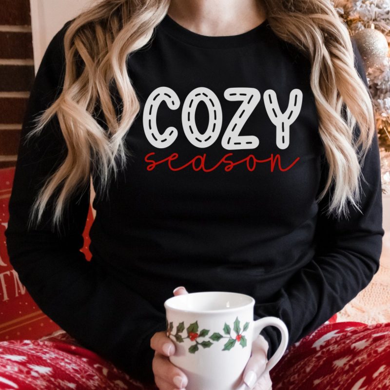 Woman with a sweatshirt that says Cozy Season. 