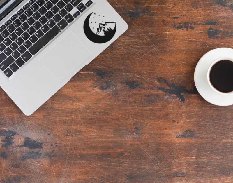 Moon, stars, mountain and trees decal on a laptop