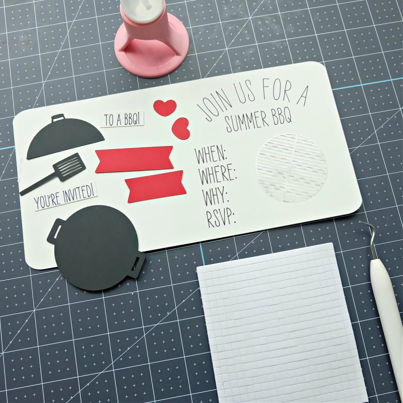 Pieces of a Cricut BBQ invitation laying on a work surface waiting to be assembled