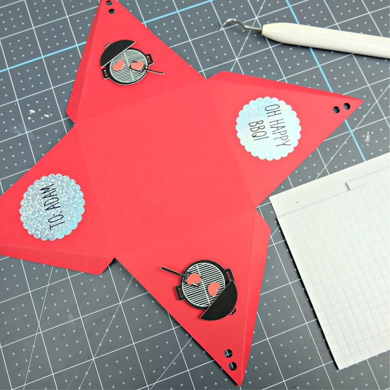 Pieces of a Cricut BBQ party favor box laying on a work surface waiting to be assembled