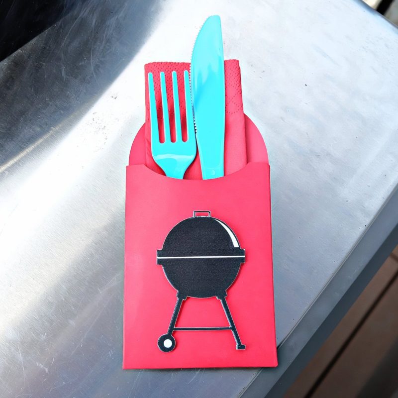 Cricut BBQ utensil holder sitting next to a BBQ.
