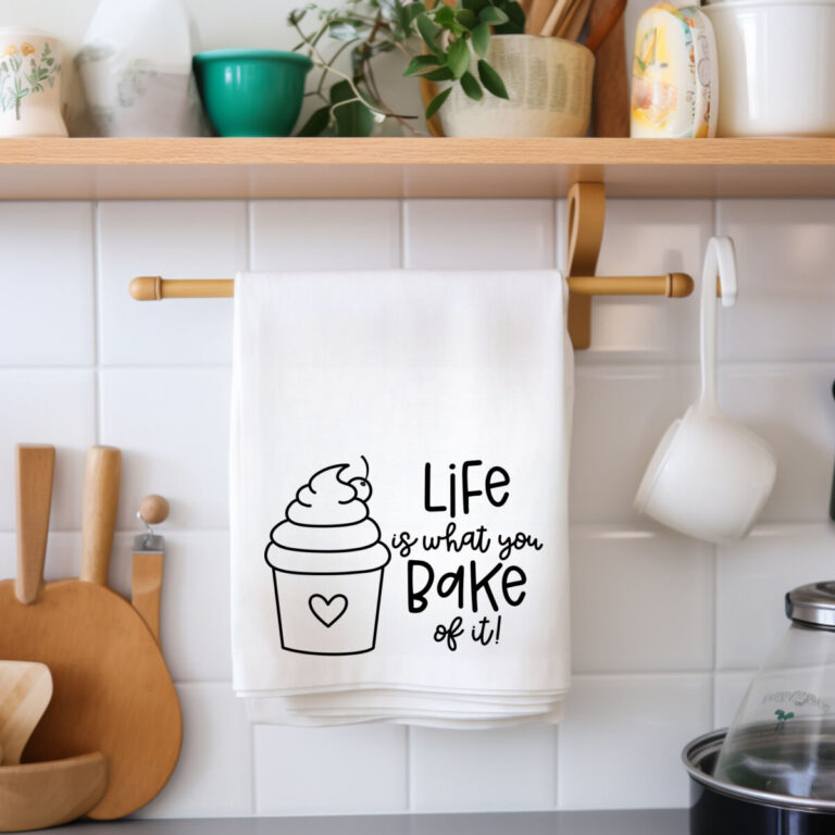 Life Is What You Bake It SVG From Hello Creative Family. SVG is on a dish towel hanging in the kitchen.