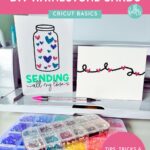 Two rhinestone cards sitting in front a a Cricut Maker 3 with supplies for making rhinestone cards