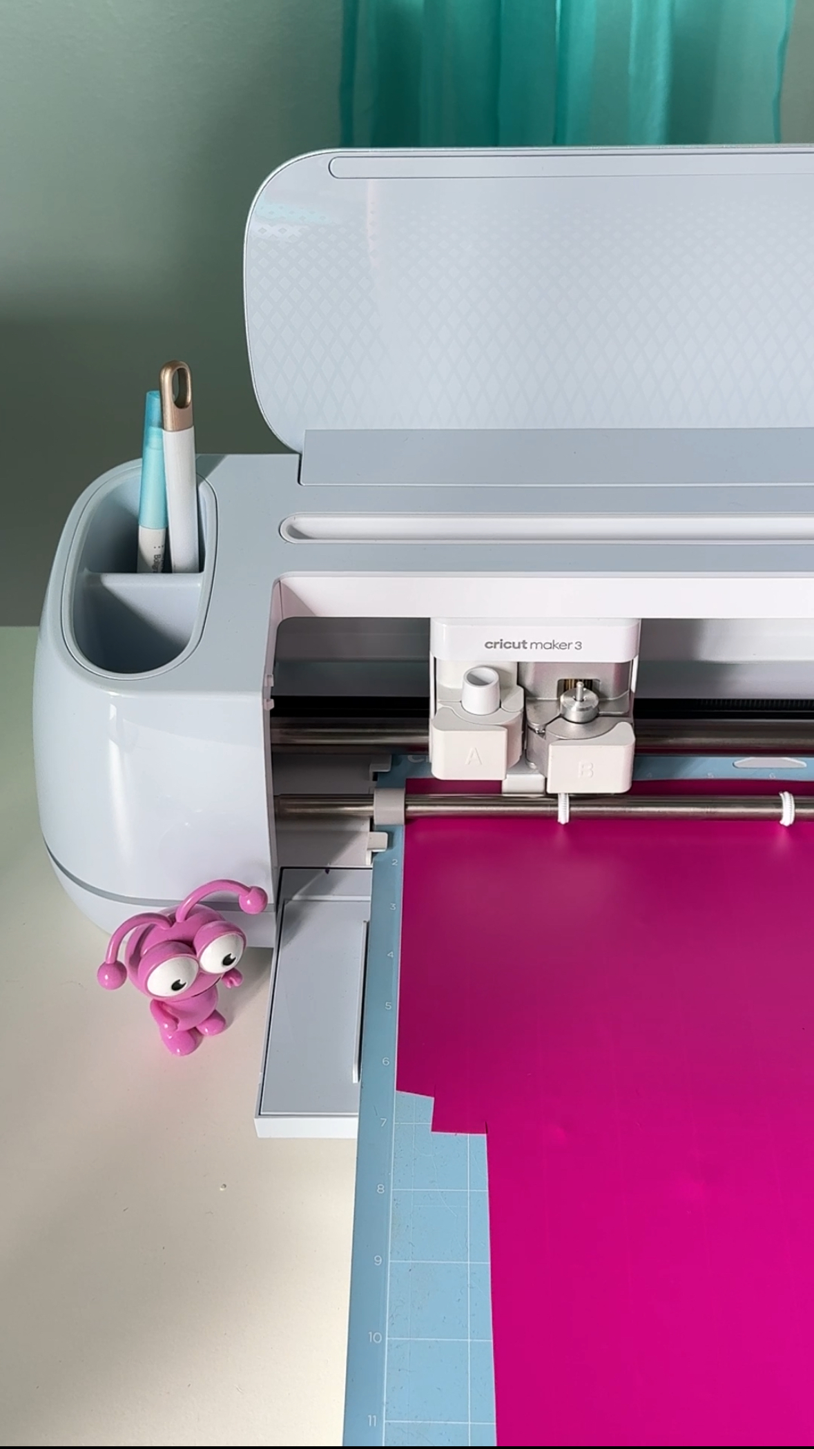 Cricut cutting machine cutting pink vinyl