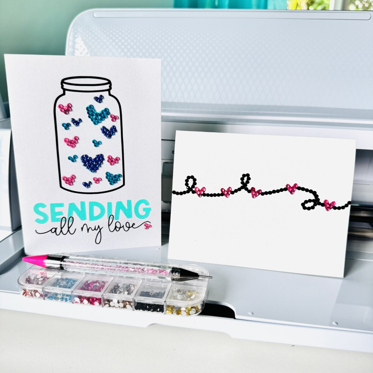Two Rhinestone Cards sitting in front of a Cricut cutting machine