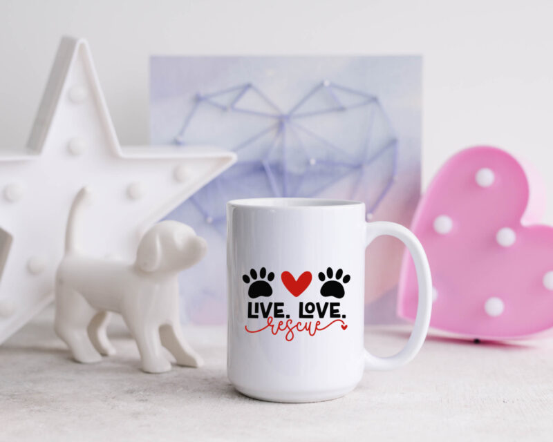 Live Love Rescue Mug sitting on a counter with a white ceramic dog, heart and star.