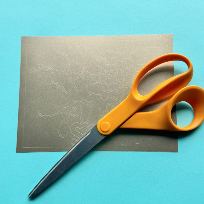 Use a pair of scissors to cut your vinyl around the box that you cut around your design. Remove the extra vinyl from around the box. I like to leave my vinyl on the Cricut Mat to help keep the design in place.